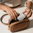 Anker A1638 white power bank being dropped into a small handbag, showing its pocket size - CairoVolt