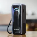 Anker Prime Fusion A1339 power bank on a wooden table, smart display showing 100% with lanyard — CairoVolt