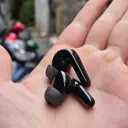 ساوندكور R60i NC earbuds in palm showing charging contacts and ear tips - CairoVolt