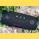 صورة حقيقية لأزرار التحكم العلوية بسماعة JBL Charge 6 وسط النباتات - كايرو فولت