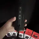 JBL Flip 6 JBLFLIP6 held in hand showing back panel buttons, retail boxes behind - CairoVolt
