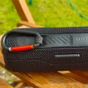 JBL Flip 7 JBLFLIP7 back panel close-up with carabiner attached, on a garden chair - CairoVolt