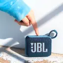 سماعة JBL Go 4 زرقاء في الخارج وإصبع يضغط على أزرار التحكم العلوية - كايرو فولت
