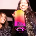 JBL Pulse 5 JBLPULSE5 held up glowing by smiling women at a party, lifestyle shot - CairoVolt