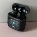 علبة سماعة JBL Tour Pro 2 الذكية مفتوحة على طاولة وشاشتها موضحة أزرار الموسيقى - كايرو فولت